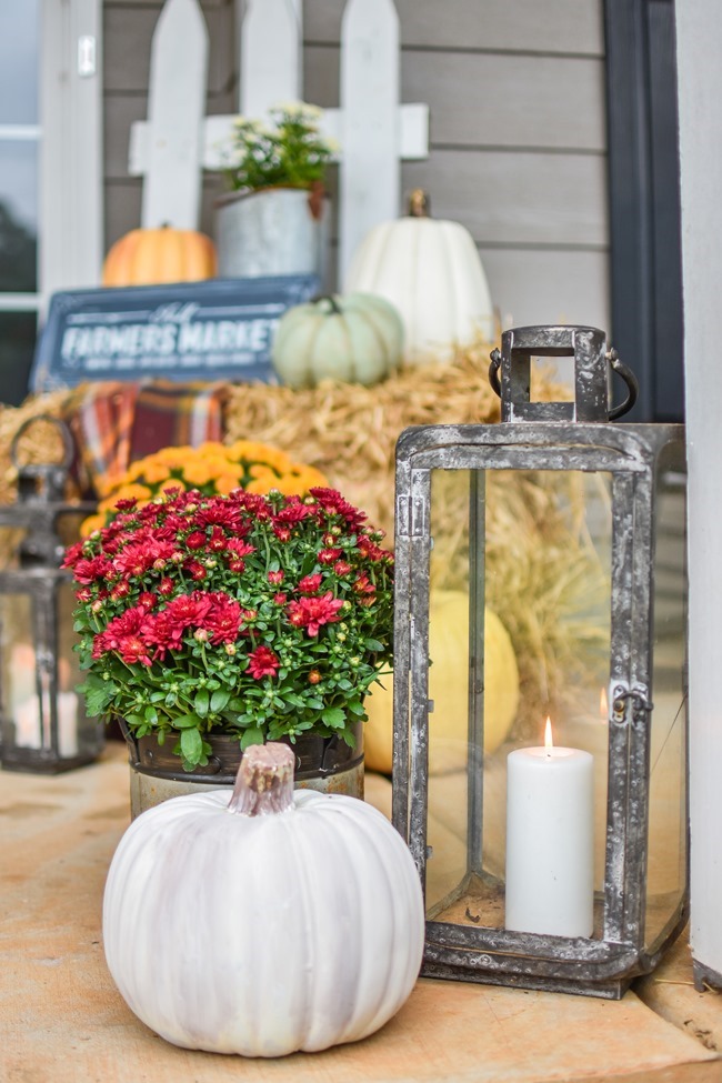 Farmhouse fall front porch with lots of mums, hay and pumpkins-1