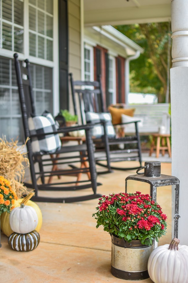 Farmhouse fall front porch with lots of mums, hay and pumpkins-29
