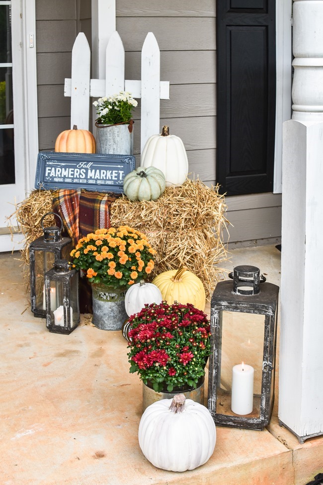 Farmhouse fall front porch with lots of mums, hay and pumpkins-34