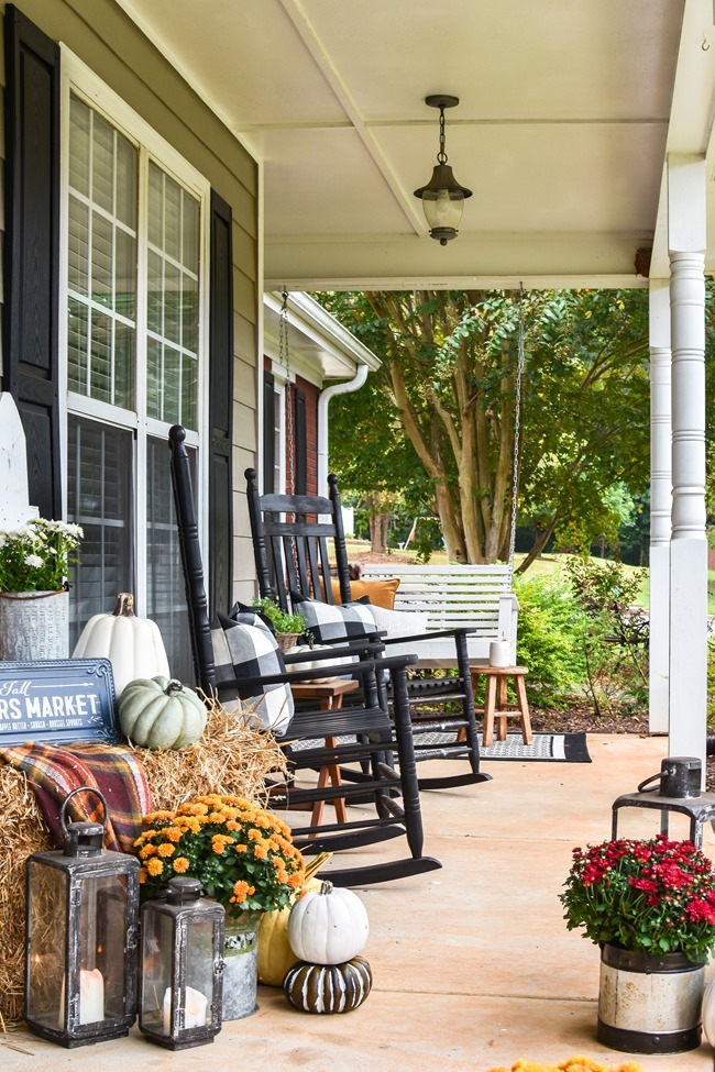 Farmhouse fall front porch with lots of mums, hay and pumpkins-37