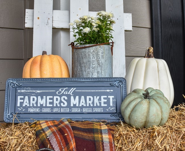 Farmhouse fall front porch with lots of mums, hay and pumpkins-41