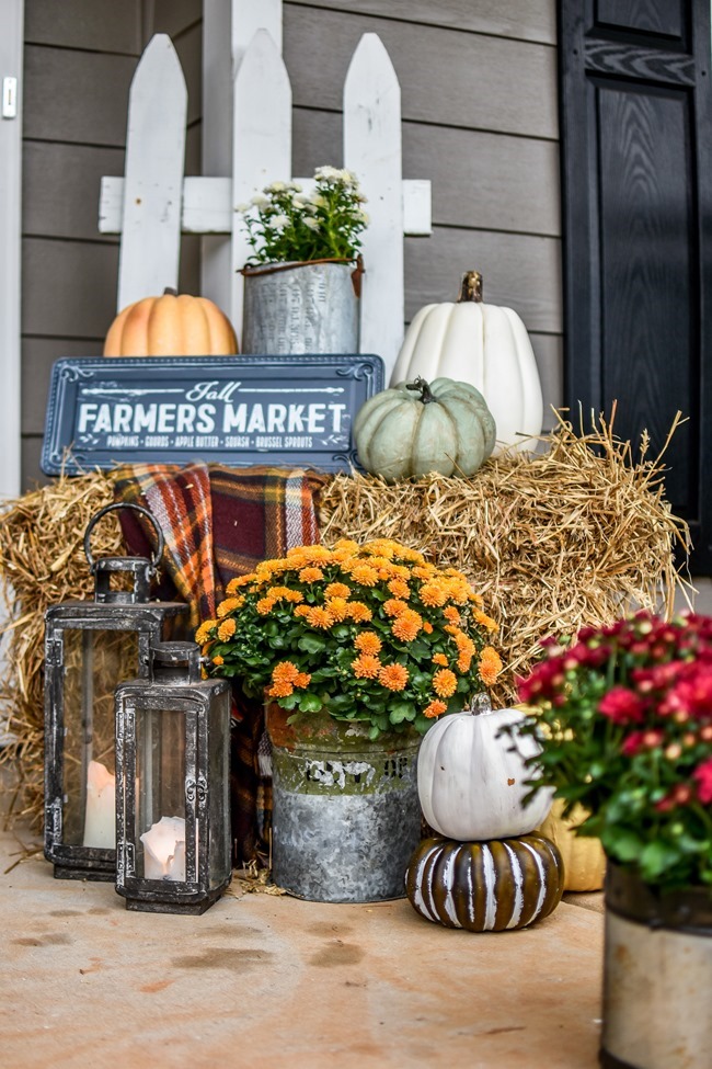 Farmhouse fall front porch with lots of mums, hay and pumpkins-5