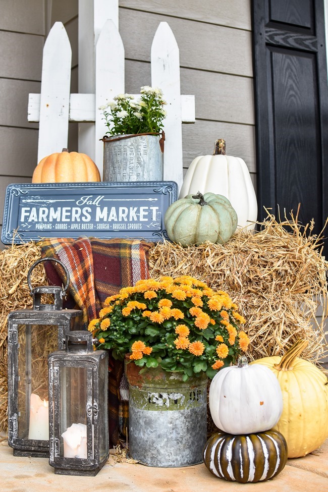 Farmhouse fall front porch with lots of mums, hay and pumpkins-6